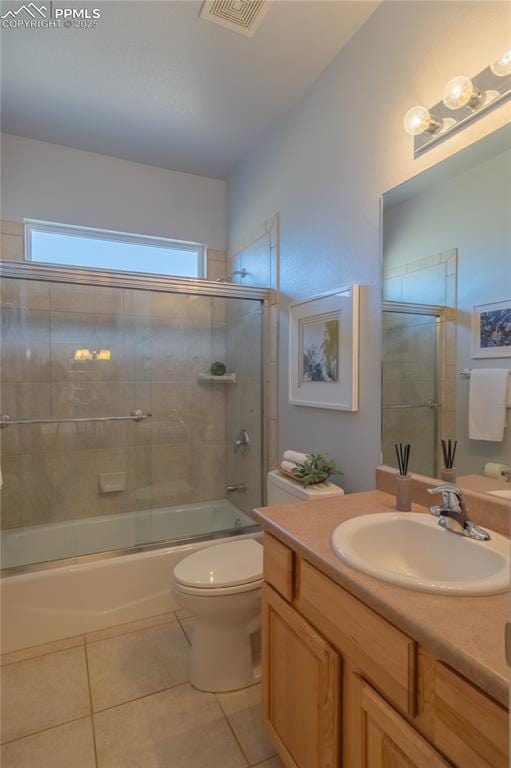 bathroom with tile patterned flooring, toilet, shower / bath combination with glass door, vanity, and visible vents