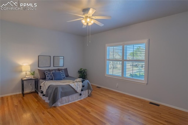 bedroom with visible vents, baseboards, and wood finished floors