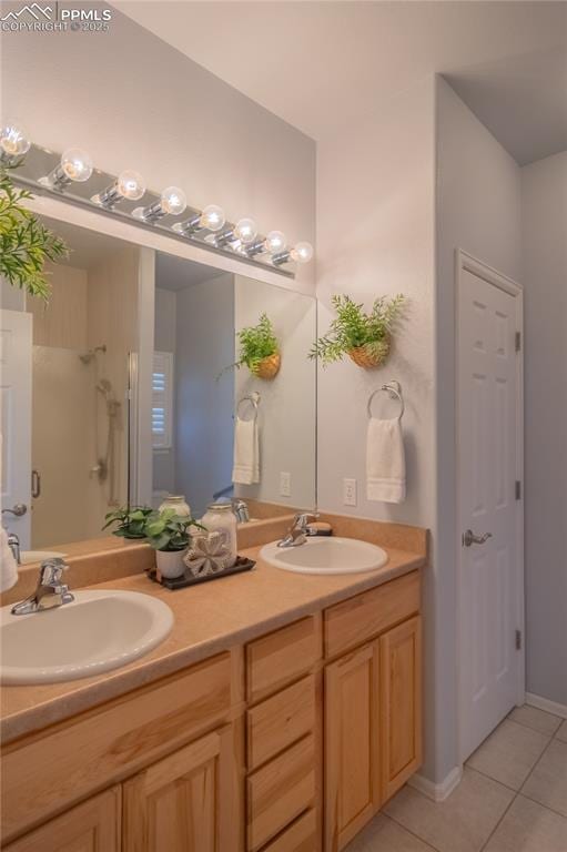 bathroom featuring double vanity, a stall shower, a sink, and tile patterned floors