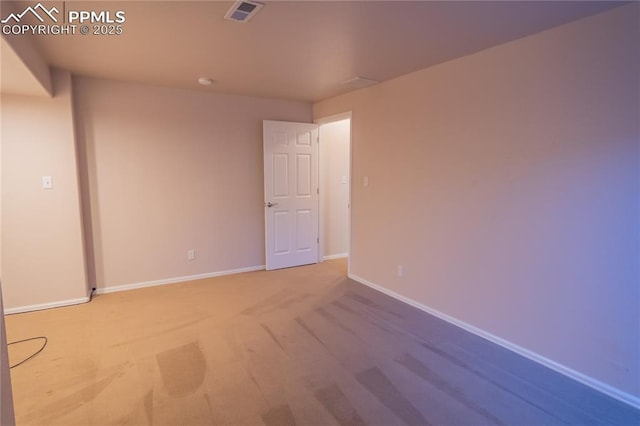 unfurnished room featuring carpet floors, visible vents, and baseboards