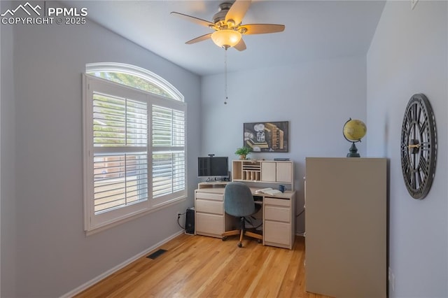 office area with light wood-type flooring, visible vents, ceiling fan, and baseboards