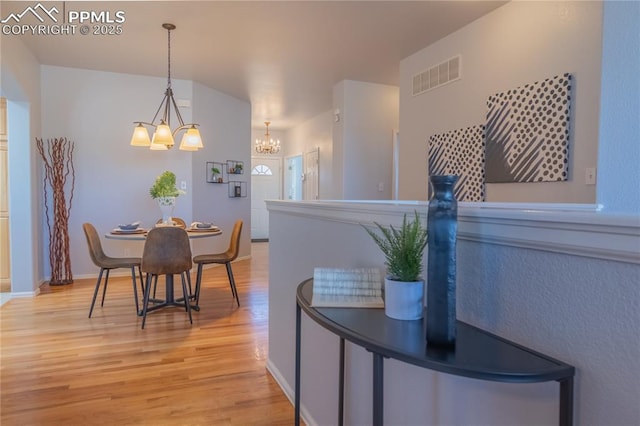 dining space featuring a chandelier, visible vents, light wood-style flooring, and baseboards