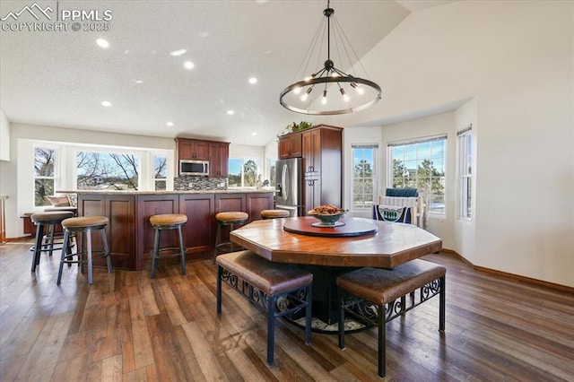 dining area with dark wood-style floors, baseboards, lofted ceiling, and recessed lighting