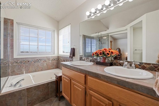 bathroom with lofted ceiling, a sink, a garden tub, and a shower stall