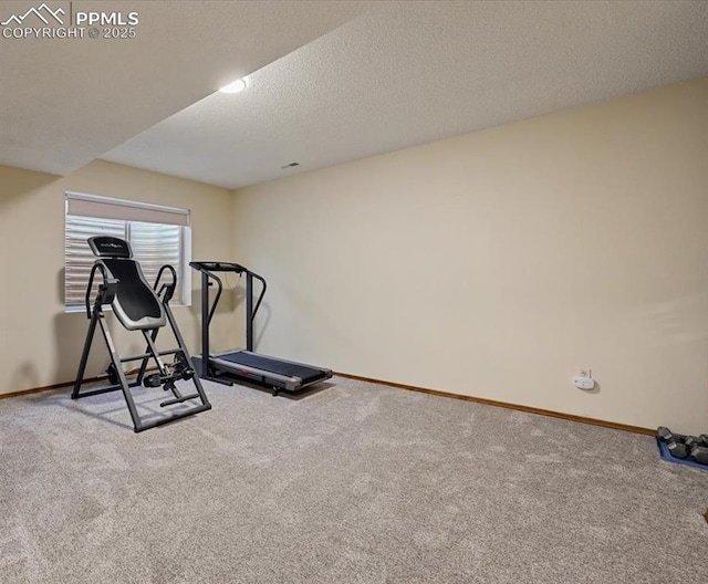 exercise room with carpet, a textured ceiling, and baseboards