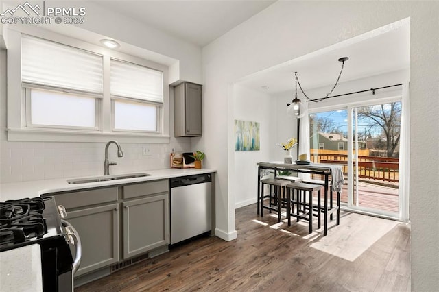 kitchen with range with gas cooktop, decorative backsplash, gray cabinetry, a sink, and dishwasher