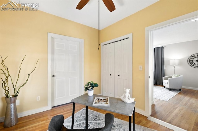 home office with light wood-type flooring, ceiling fan, and baseboards