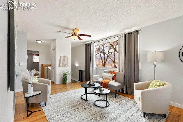 living area featuring a healthy amount of sunlight, a textured ceiling, and light wood finished floors