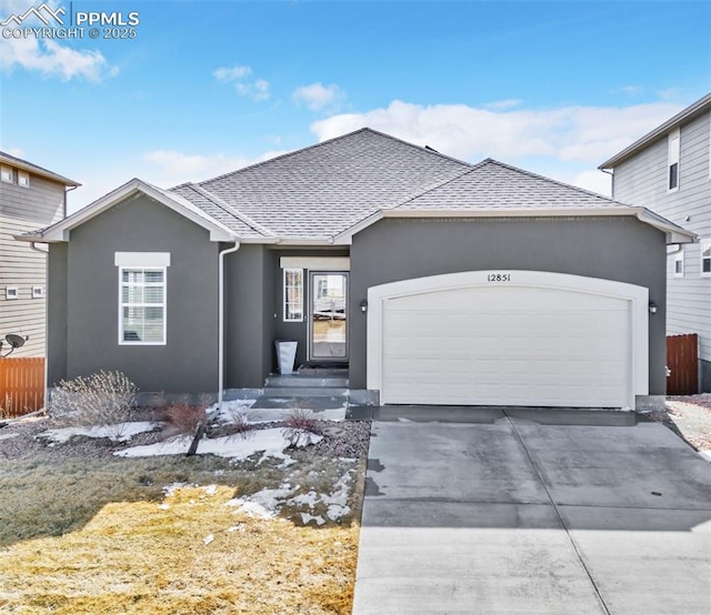 ranch-style house with stucco siding, driveway, and an attached garage