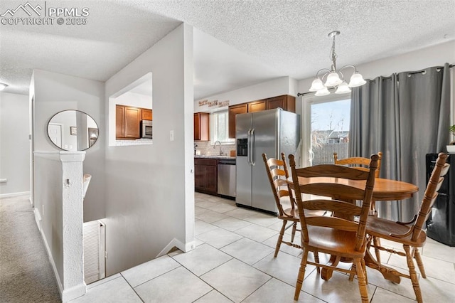 dining room with a notable chandelier, light tile patterned flooring, visible vents, and baseboards