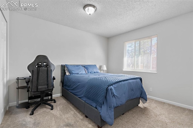 carpeted bedroom with baseboards and a textured ceiling