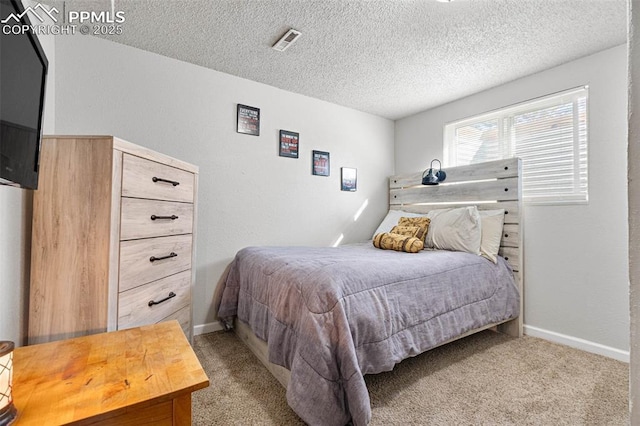 bedroom with visible vents, baseboards, light colored carpet, and a textured ceiling