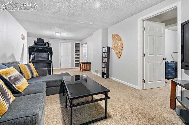 carpeted living area featuring baseboards, visible vents, and a textured ceiling