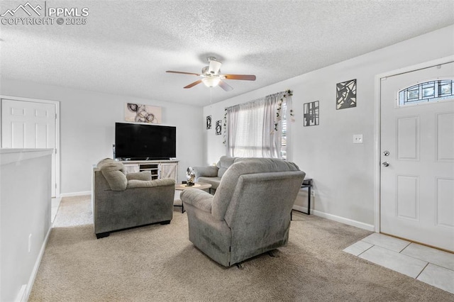 living area featuring a textured ceiling, baseboards, carpet floors, and ceiling fan