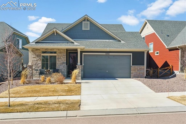 craftsman-style home with a shingled roof, concrete driveway, stone siding, an attached garage, and covered porch