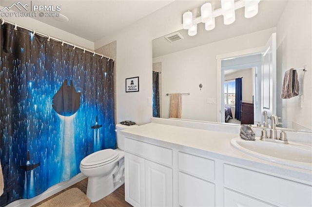 ensuite bathroom featuring visible vents, toilet, connected bathroom, vanity, and wood finished floors