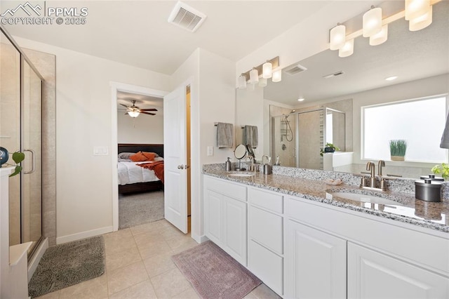 bathroom with double vanity, a stall shower, visible vents, tile patterned flooring, and a sink