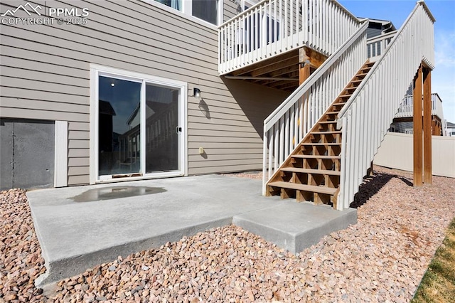 view of exterior entry featuring a patio area and fence