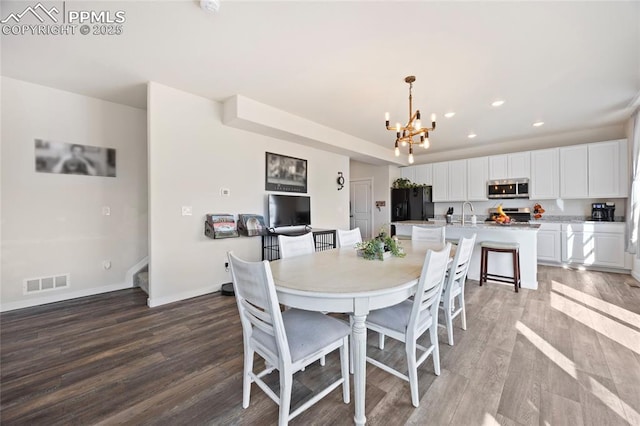 dining area with a chandelier, recessed lighting, wood finished floors, visible vents, and baseboards