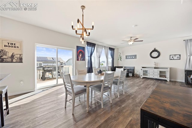 dining area featuring dark wood-style floors, baseboards, and ceiling fan with notable chandelier