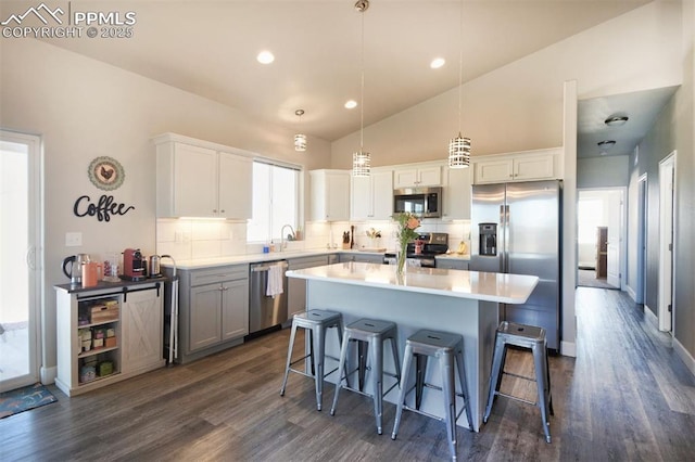 kitchen featuring stainless steel appliances, backsplash, a center island, and a kitchen breakfast bar