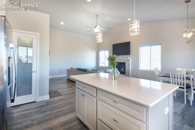 kitchen with dark wood-style floors, a wealth of natural light, and a lit fireplace