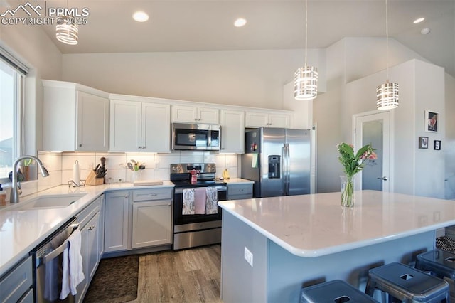 kitchen featuring backsplash, stainless steel appliances, a sink, and light countertops