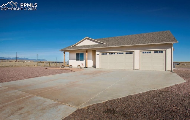 single story home with an attached garage, roof with shingles, concrete driveway, and stucco siding