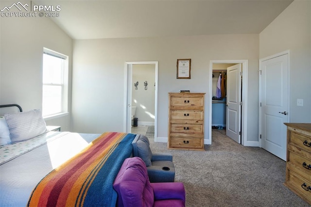 bedroom with a walk in closet, a closet, light colored carpet, ensuite bathroom, and baseboards