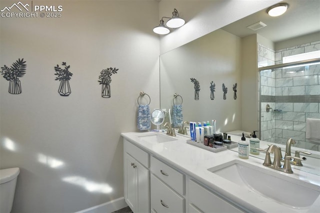 bathroom with toilet, tiled shower, a sink, and visible vents