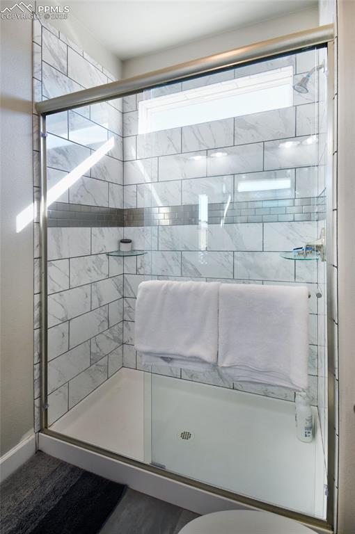 bathroom with a shower stall and a wealth of natural light