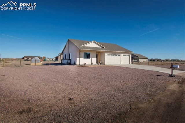 view of front facade with a garage, concrete driveway, and stucco siding