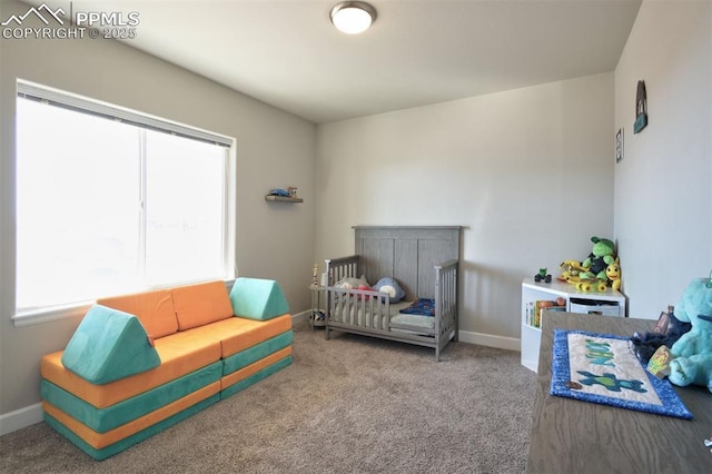 bedroom with a nursery area, carpet flooring, and baseboards