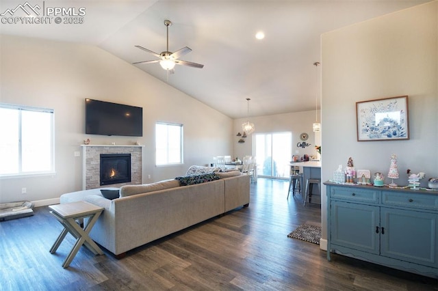 living area featuring ceiling fan with notable chandelier, dark wood-style flooring, and a wealth of natural light