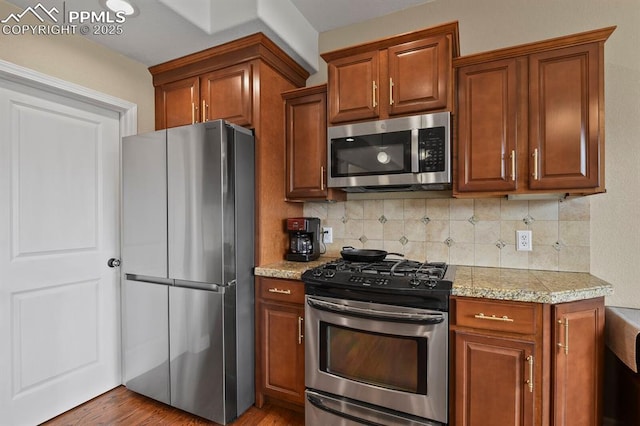 kitchen featuring stainless steel appliances, brown cabinetry, and decorative backsplash