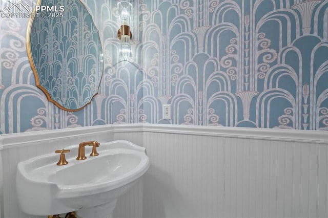 bathroom with a wainscoted wall and a sink