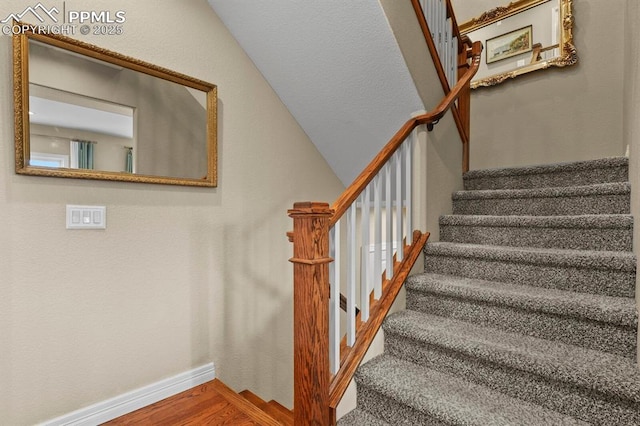 stairs featuring baseboards and wood finished floors