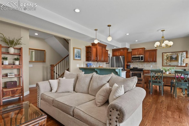 living room featuring recessed lighting, dark wood-style flooring, an inviting chandelier, and stairs