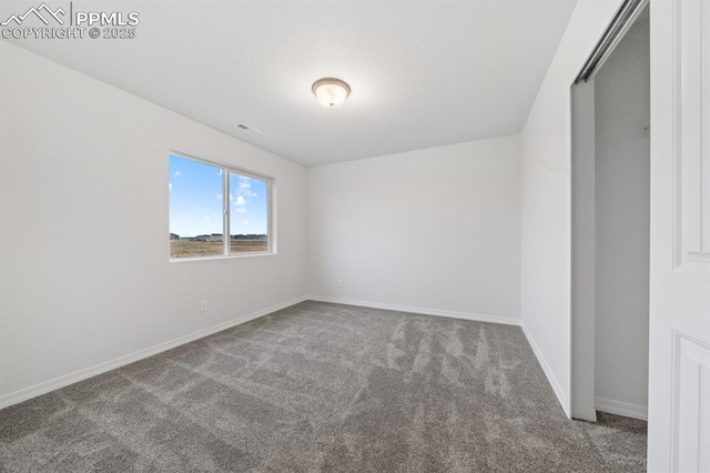 carpeted spare room with visible vents and baseboards