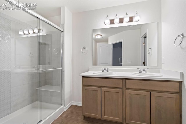 full bath featuring a sink, a shower stall, and double vanity