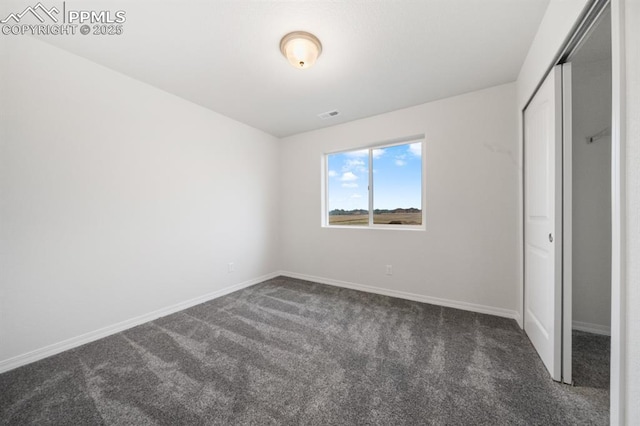 unfurnished bedroom with carpet floors, a closet, visible vents, and baseboards