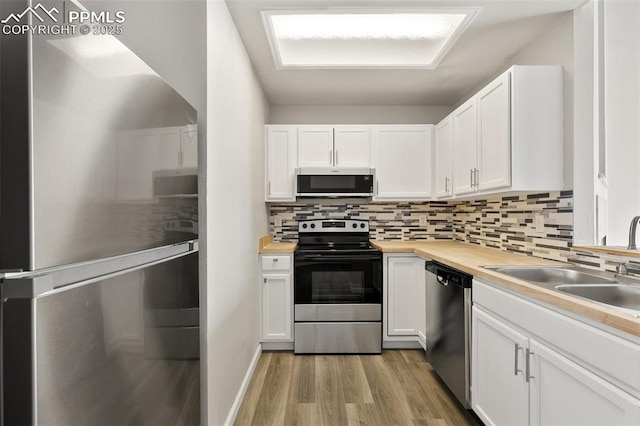 kitchen featuring light wood-style floors, tasteful backsplash, appliances with stainless steel finishes, and white cabinets