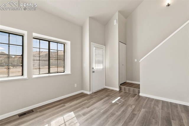 entrance foyer featuring baseboards, visible vents, and wood finished floors