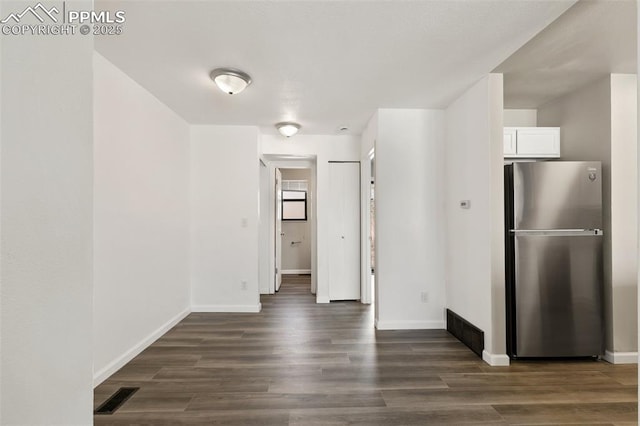 interior space featuring dark wood-type flooring, visible vents, and baseboards