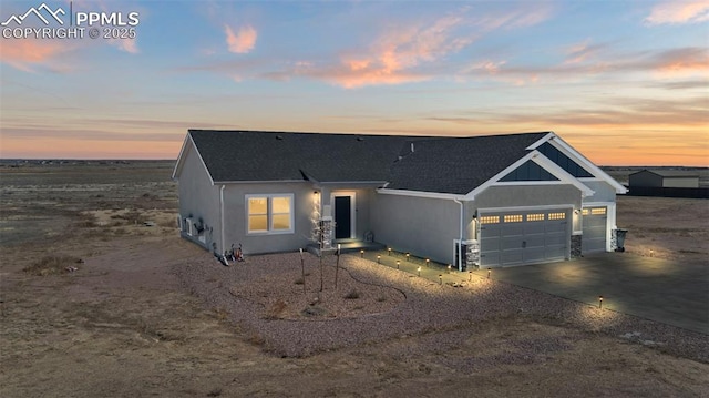 1086 N Purcell Blvd, Pueblo West, CO 81007 - view of front facade with driveway, roof with shingles, an attached garage, and stucco siding