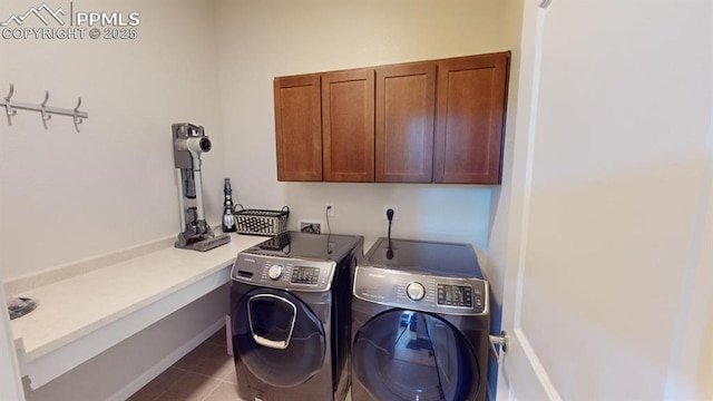 washroom featuring tile patterned flooring, washing machine and dryer, and cabinet space