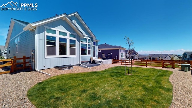 rear view of property featuring a residential view, a fenced backyard, and a yard