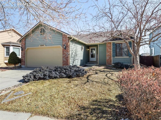 ranch-style house featuring an attached garage, driveway, fence, and brick siding