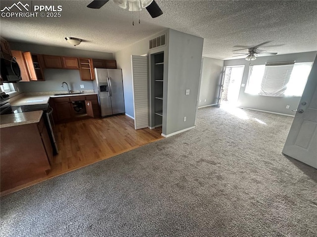 kitchen featuring carpet, light countertops, visible vents, appliances with stainless steel finishes, and a sink