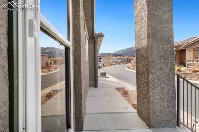 view of patio featuring a mountain view, a balcony, and a residential view